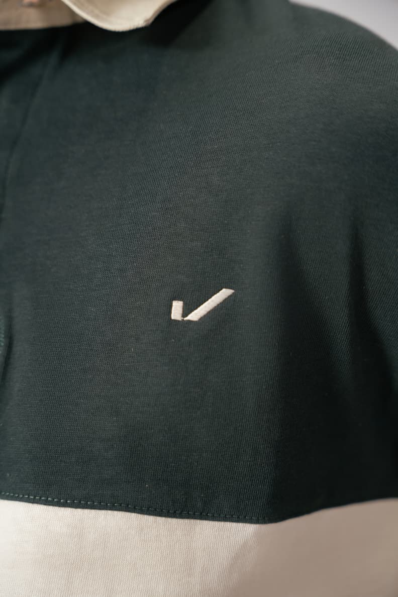 Close-up of logo on green rugby shirt chest Scarab/Cannoli Cream