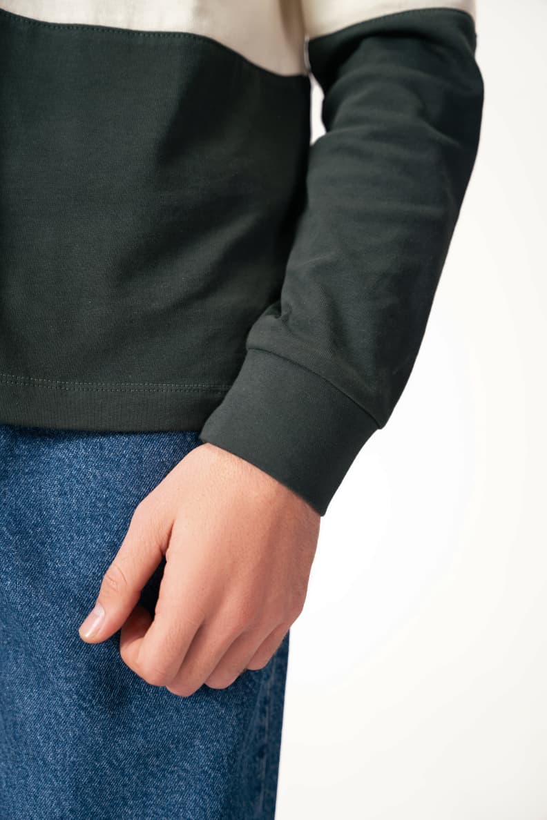 Close-up of green rugby shirt cuff and hem Scarab/Cannoli Cream